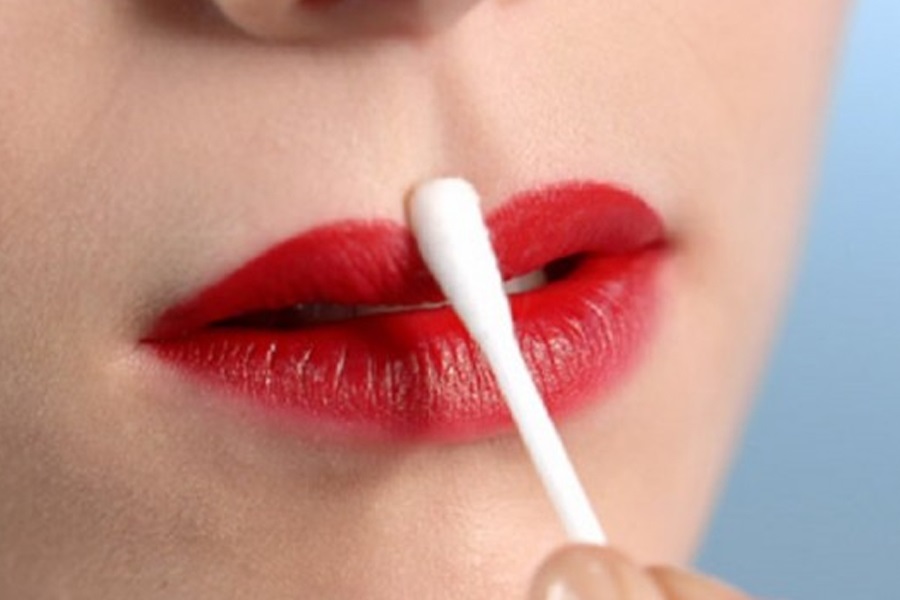 Sử dụng tăm bông và nước muối sinh lý để vệ sinh nhẹ nhàng môi sau phun xăm