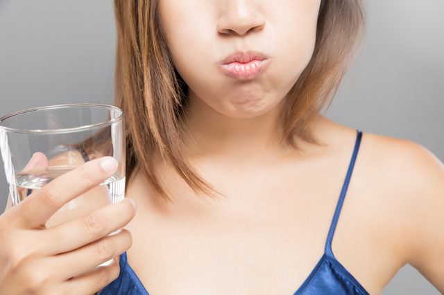Súc miệng với nước muối ấm cải thiện tình trạng vướng ở cổ họng nhưng không đau