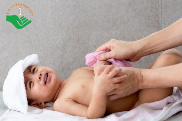 Khi bé bị sốt tay chân lạnh, mẹ dùng khăn ấm lau người để bé hạ sốt